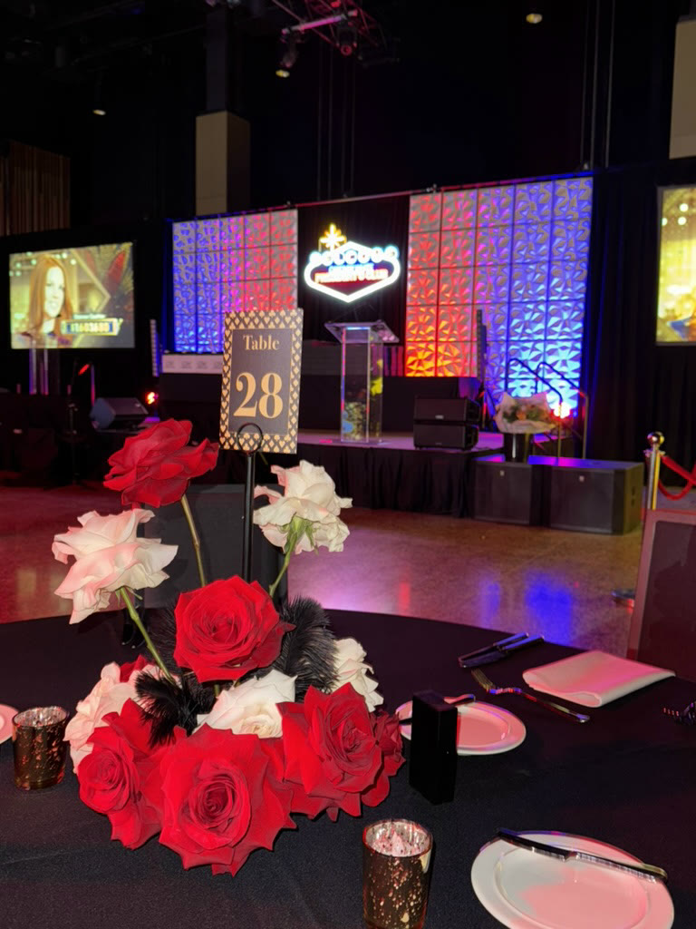 Red rose centerpiece on a banquet table in front of the stage