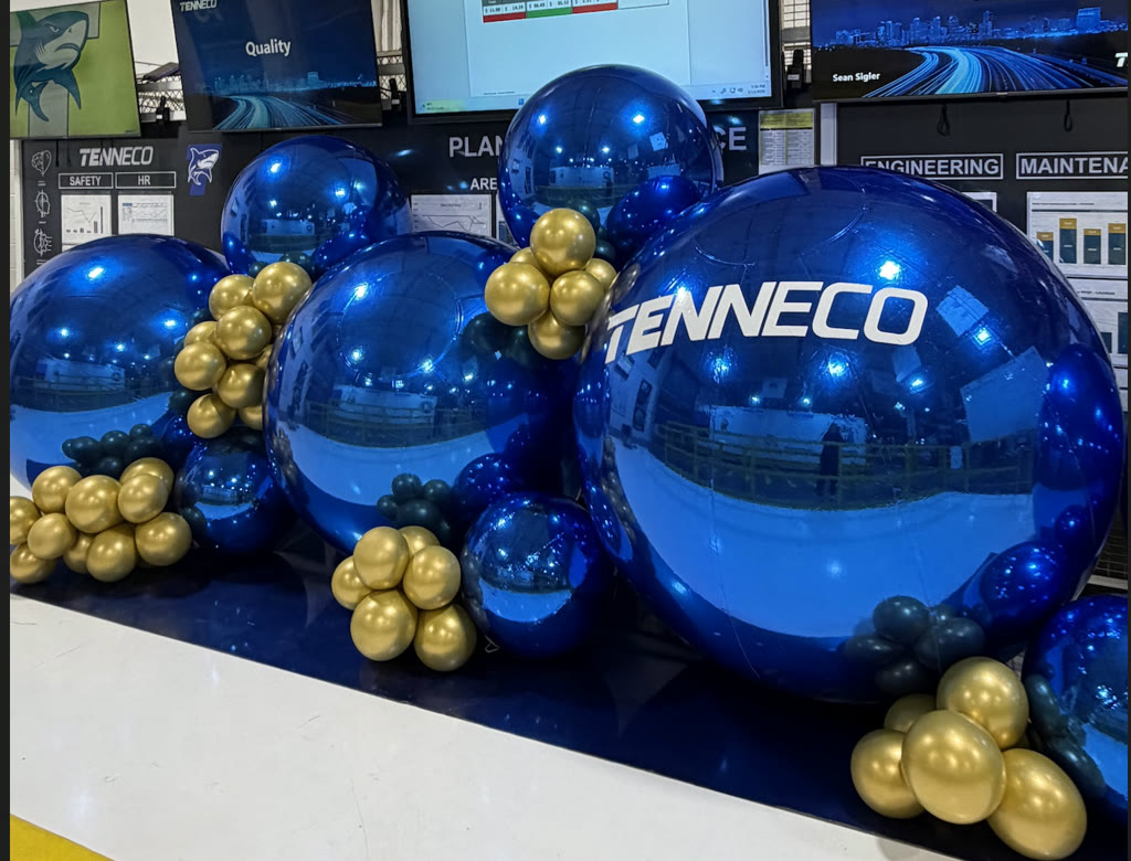 Chrome blue Tenneco orbs with gold balloon clusters on the plant floor