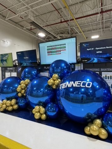 Chrome blue and gold Tenneco balloon installation on a plant floor