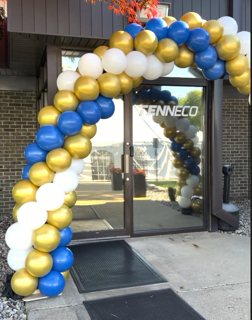 Blue, gold, and white balloon arch framing the Tenneco entrance doors