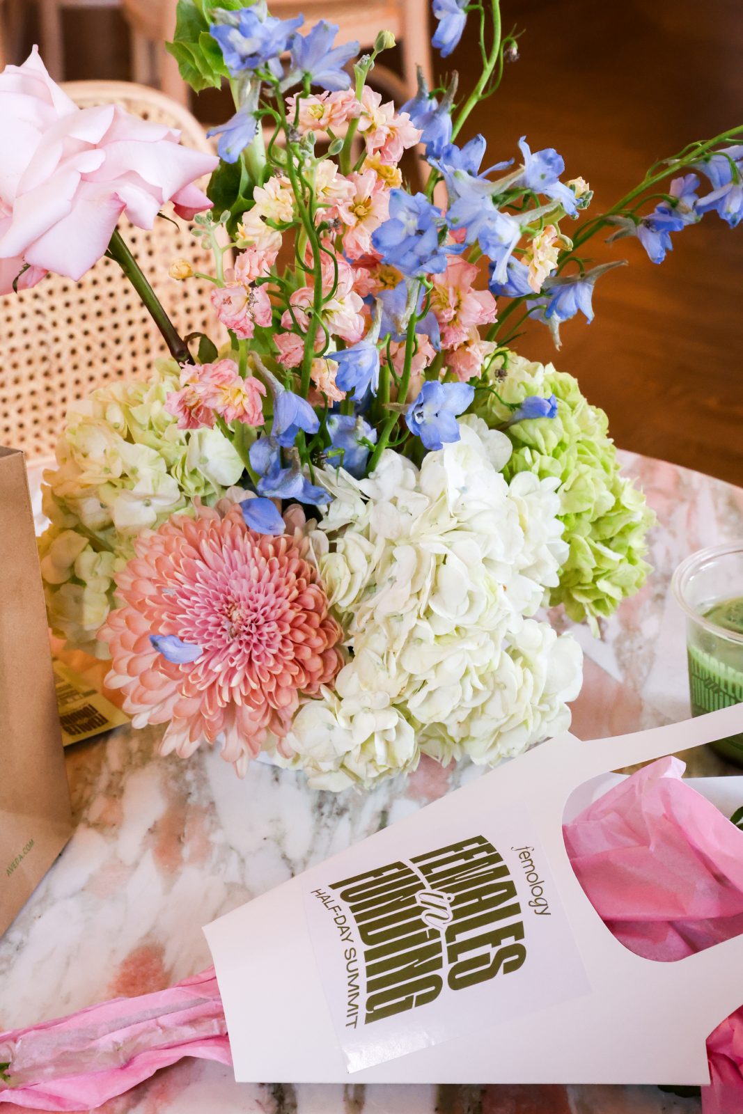 Lush pastel floral installation beside the Females in Funding branded backdrop