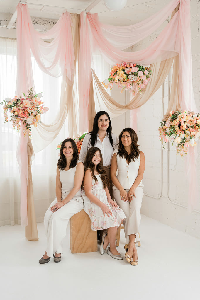 The KRP Events team seated beneath blush draping and florals